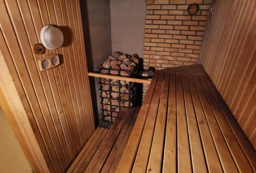 a sauna with a stack of logs and a wooden floor at Kemeri Roomstay & Sauna in Jūrmala