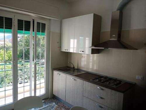 a kitchen with a sink and a stove top oven at La casa di John in Finale Ligure