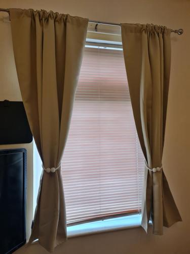 a window with brown curtains in a room at KELVIN HOUSE in Durham