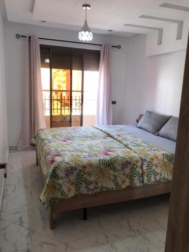 um quarto com uma cama com colcha floral em Studio au résidence MALAK em Agadir