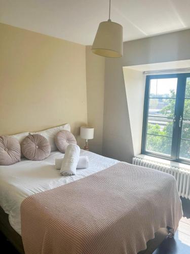 - une chambre avec un lit doté d'oreillers et d'une fenêtre dans l'établissement Flat 1, à Hendon