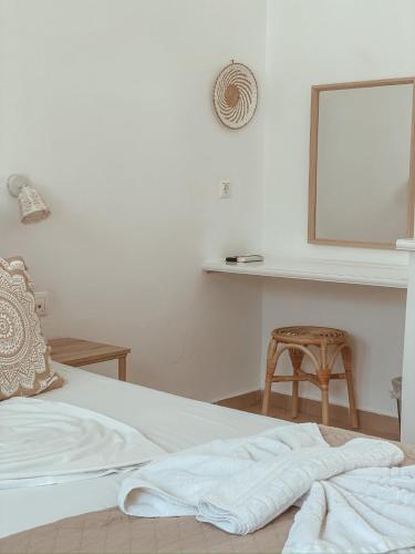a bedroom with a bed with a mirror and a stool at Lindos Athena in Líndos