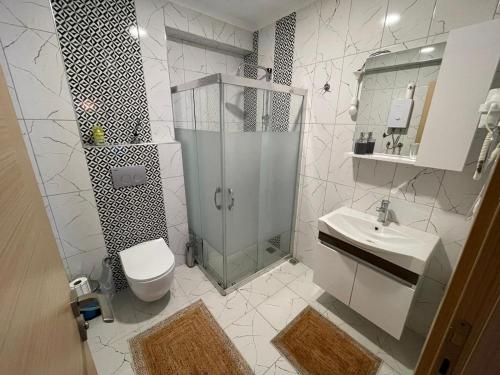 een badkamer met een douche, een toilet en een wastafel bij Alpha Rezidans Mozyr Dom in Fethiye