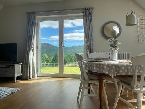 a dining room with a table and a large window at Little Thistle Apartment in Whitebridge