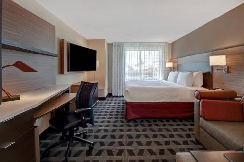 Habitación de hotel con cama y escritorio con ordenador en TownePlace Suites Las Vegas Airport South, en Las Vegas