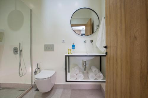 ein Badezimmer mit einem Waschbecken, einem WC und einem Spiegel in der Unterkunft White River Villa in Nydri