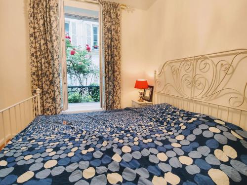 um quarto com uma cama grande e uma janela em Cozy apartment with a garden view in the 17th quartier em Paris