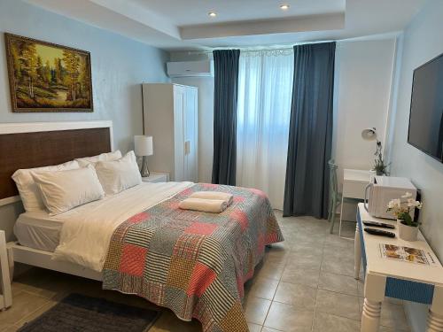 um quarto com uma cama, uma secretária e uma televisão em Noe Hotel ,1 Bed Room 2 Near to the beach em Punta Cana