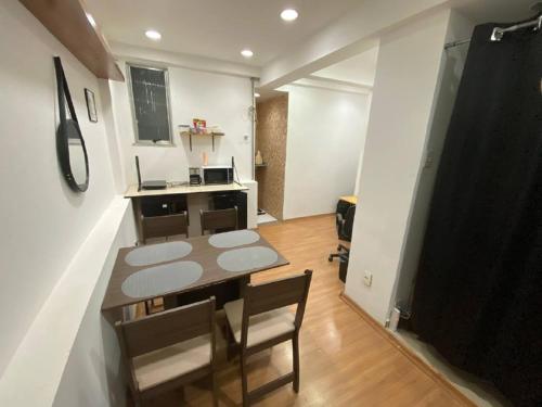 uma cozinha com mesa e cadeiras num quarto em Vai ser feliz no Rio de Janeiro