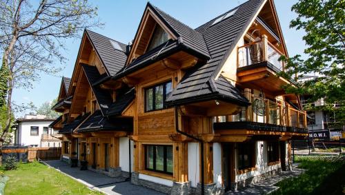 una casa de madera con techo negro en Aparthotel Merynos, en Zakopane