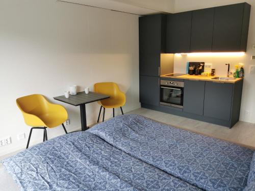 1 dormitorio con 1 cama, mesa y sillas en Lofoten Studio Apartment, Vestermyrveien 11 Svolvær, en Svolvær