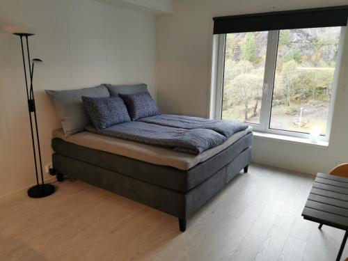 Lofoten Studio Apartment, Vestermyrveien 11 Svolvær في سفولفير: سرير في غرفة مع نافذة كبيرة