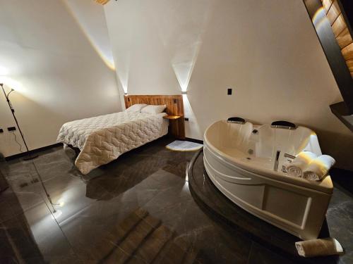 a bathroom with a tub next to a bed at Wind Houses, Casas de Viento in Monteverde Costa Rica