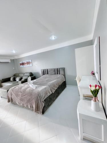 a white bedroom with a bed and a couch at Sea sand sun Condominiums in Rayong