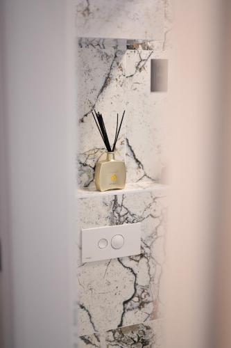 a white marble wall with a vase on a shelf at Luxury Rooms "Kaleta" in Trogir