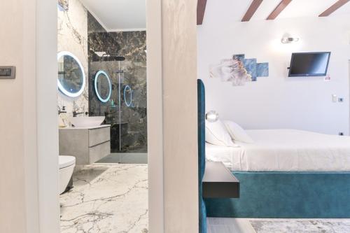 ein Schlafzimmer mit einem Bett und ein Badezimmer mit einer Dusche in der Unterkunft Luxury Rooms "Kaleta" in Trogir