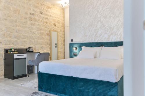 a bedroom with a large bed and a desk at Luxury Rooms "Kaleta" in Trogir