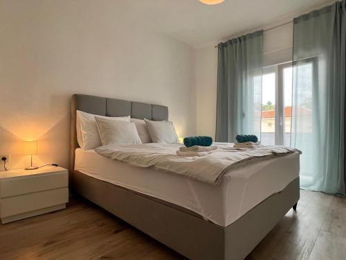 a bedroom with a large bed and a window at Apartments Tariba Milica in Rab