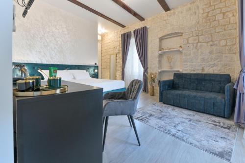 a hotel room with a bed and a couch at Luxury Rooms "Kaleta" in Trogir