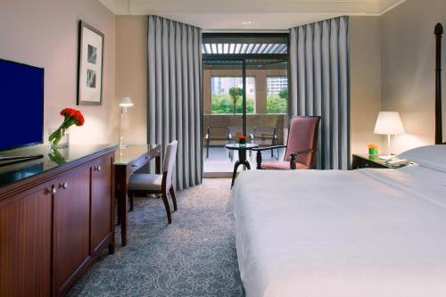 a hotel room with a large bed and a desk and a desk at Sheraton Towers Singapore Hotel in Singapore