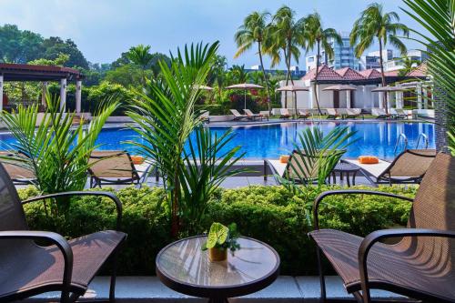 a patio with tables and chairs and a swimming pool at Sheraton Towers Singapore Hotel in Singapore