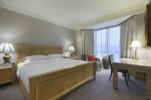 a hotel room with a large bed and a desk at Sheraton Towers Singapore Hotel in Singapore