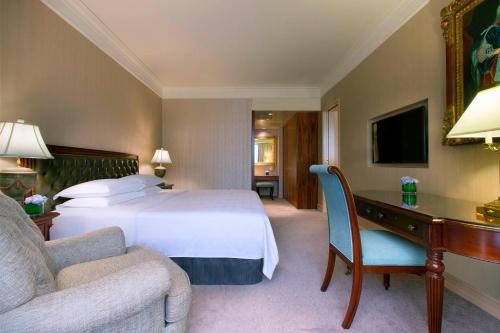 a bedroom with a bed and a desk and a couch at Sheraton Towers Singapore Hotel in Singapore