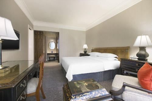 a hotel room with a bed and a desk with a desk at Sheraton Towers Singapore Hotel in Singapore