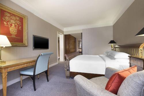 a hotel room with a bed and a desk at Sheraton Towers Singapore Hotel in Singapore