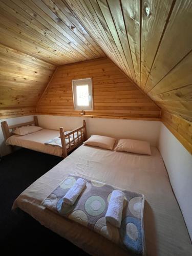 コラシンにあるHoliday House Taraの木造キャビン内のベッドルーム1室(ベッド2台付)