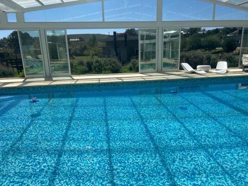 a large swimming pool with blue water at Tandil del Lago in Tandil