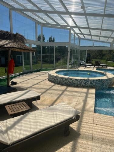 a patio with a swimming pool and a building with windows at Tandil del Lago in Tandil
