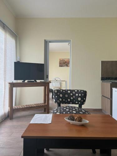 a living room with a table and a tv at Tandil del Lago in Tandil