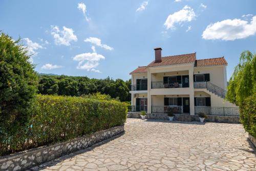 a large white house with a stone driveway at Arte villa Margarita apartment in Sami