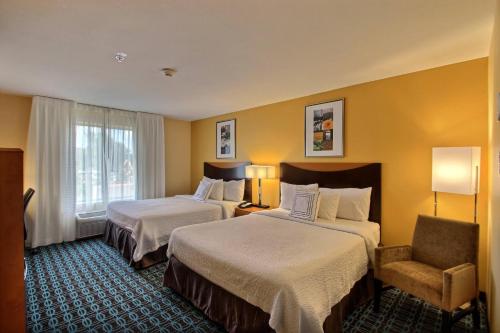 ein Hotelzimmer mit 2 Betten und einem Stuhl in der Unterkunft Fairfield Inn & Suites by Marriott Milwaukee Airport in Oak Creek