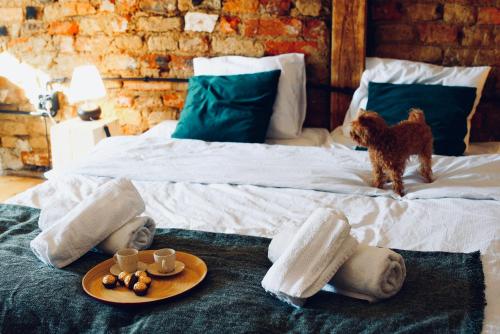 a bed with two people and a dog standing on it at Loft with Lake View Pasym Koneser in Pasym