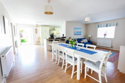 a dining room and living room with a table and chairs at 2100 Sq Ft Beach House with large garden in Earnley