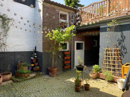 un patio con macetas y un edificio en Casa Enana, en Waldfeucht