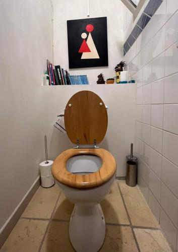 La salle de bains est pourvue de toilettes et d'un siège en bois. dans l'établissement Duplex proche mer, avec swimspa terrasse, jardin et barbecue, à Lapalme