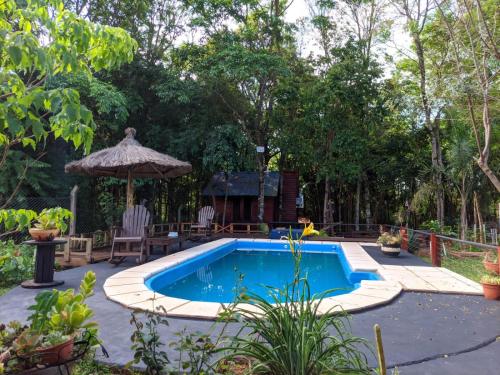 una piscina en un patio con mesa y sillas en Cabañas El Portal en Jardín América