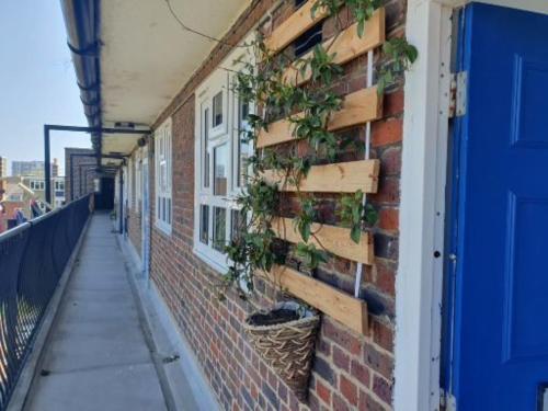 a brick building with plants on the side of it at Stylish 2 Bed Flat in Hoxton near Art Galleries in London