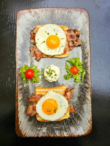 a plate of food with fried eggs and bacon at Luxury Rooms "Kaleta" in Trogir