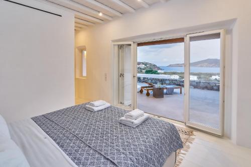a bedroom with a bed with a view of the ocean at Christina's Panormos Villa in Panormos Mykonos
