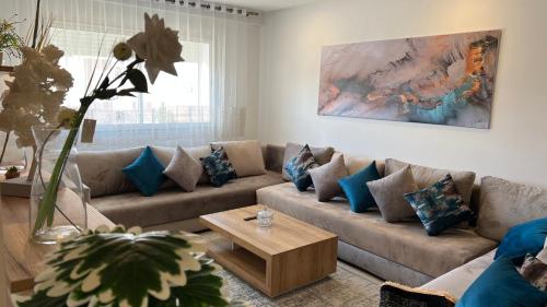 uma sala de estar com um sofá e uma mesa em Luxury Family Appart 7 Pers - CheckPoint - Oujda Center em Oujda