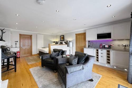 ein Wohnzimmer mit einem Sofa und Stühlen sowie eine Küche in der Unterkunft The Allanbreck Studio Glencoe in Glencoe