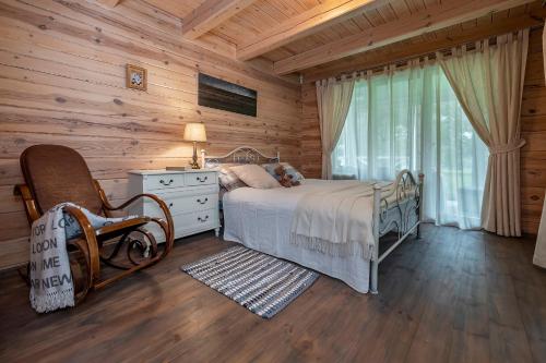 een slaapkamer met een bed in een blokhut bij Vila Shakti in Rudžionys