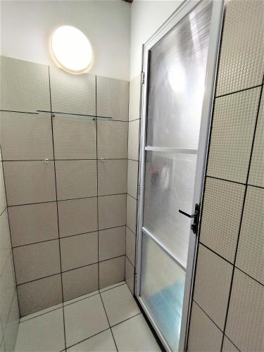 a shower with a glass door in a bathroom at Bangalô Panorâmica in Conde