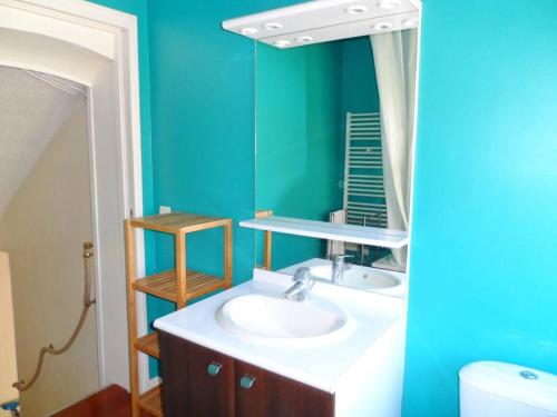 une salle de bain avec un lavabo et un miroir dans l'établissement Cabourg éventail 3min à pied de la plage, à Cabourg