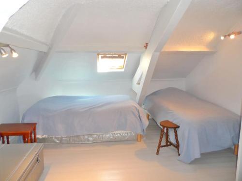 une chambre mansardée avec deux lits et une table dans l'établissement Cabourg éventail 3min à pied de la plage, à Cabourg