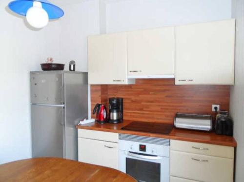 une cuisine avec des armoires blanches et un comptoir en bois dans l'établissement Cabourg éventail 3min à pied de la plage, à Cabourg